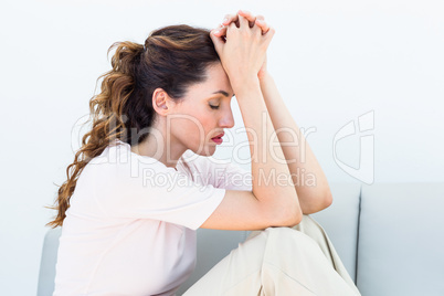 Sad brunette sitting on the couch