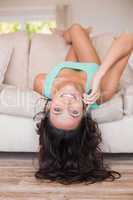 Pretty brunette lying upside down on couch