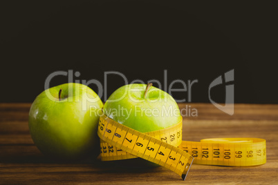 Green apples with measuring tape