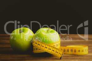 Green apples with measuring tape