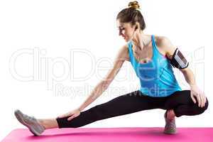 Fit woman stretching on exercise mat