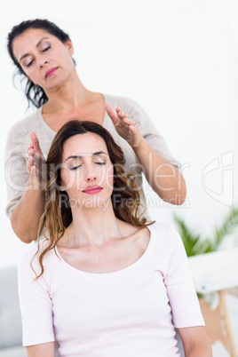 Calm woman receiving reiki treatment