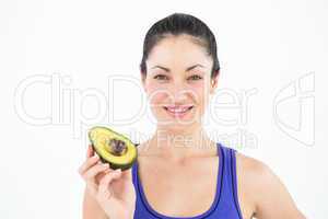 Pretty woman showing half of an avocado