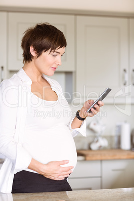 Pregnant woman using her smartphone Pregnant woman using her smartphone
