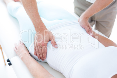 Physiotherapist examining his patients stomach