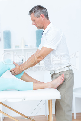 Physiotherapist doing leg massage to his patient