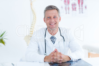 Smiling doctor sitting at his desk