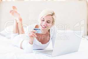 Smiling blonde woman doing online shopping
