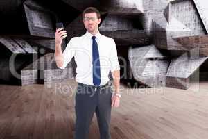 Composite image of serious businessman holding his phone