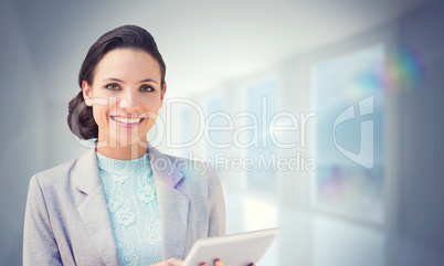 Composite image of brunette using tablet pc