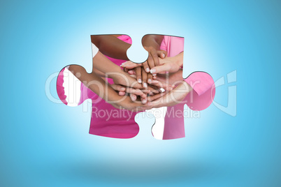 Composite image of happy women wearing breast cancer ribbons wit