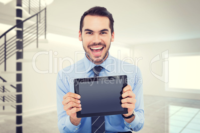 Composite image of happy businessman showing his tablet pc