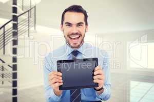 Composite image of happy businessman showing his tablet pc