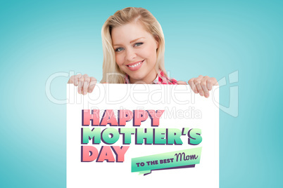 Composite image of woman beaming while holding a blank sign