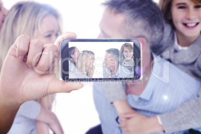 Composite image of hand holding smartphone showing