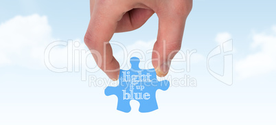 Composite image of hand holding jigsaw piece