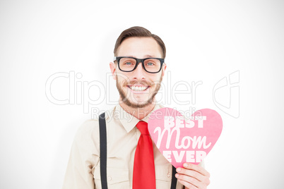 Composite image of geeky hipster smiling and holding heart card