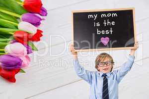 Composite image of cute pupil holding chalkboard