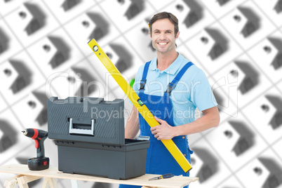 Composite image of carpenter holding spirit level at table