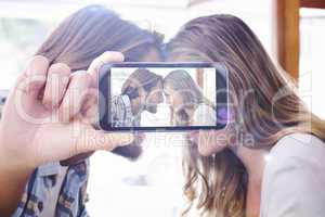 Composite image of hand holding smartphone showing