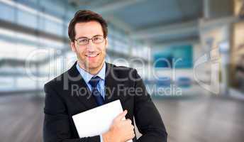 Composite image of smiling businessman holding his laptop lookin