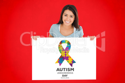 Composite image of beautiful woman holding a  board