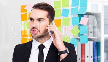 Composite image of smart businessman speaking on the phone