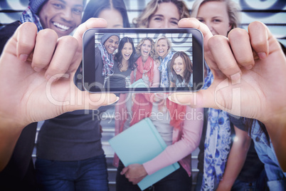 Composite image of hand holding smartphone showing