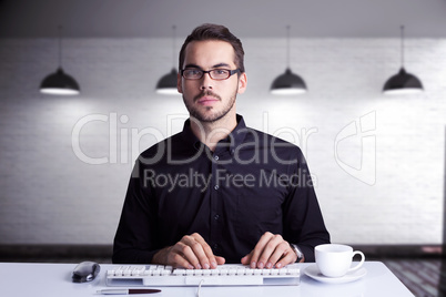 Composite image of focused businessman typing on keyboard