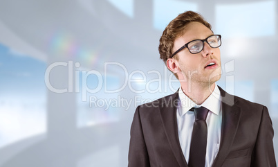 Composite image of young businessman thinking and looking up