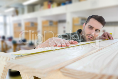 Composite image of worker measuring wooden plank