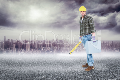 Composite image of manual worker with spirit level and toolbox