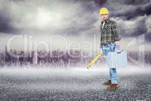 Composite image of manual worker with spirit level and toolbox