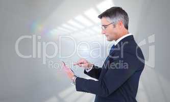 Composite image of mid section of a businessman touching tablet