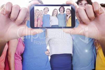 Composite image of hand holding smartphone showing