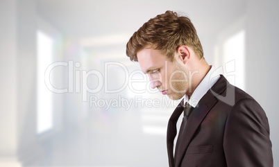 Composite image of young handsome businessman looking down