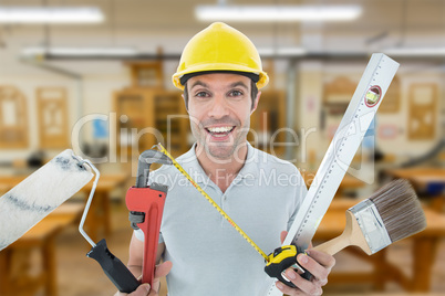 Composite image of portrait of happy worker holding various equi