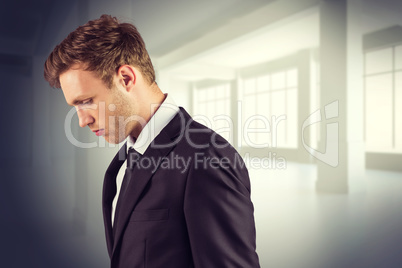 Composite image of young handsome businessman looking down