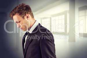 Composite image of young handsome businessman looking down