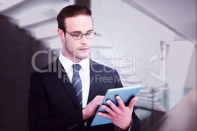 Composite image of unsmiling businessman using tablet pc