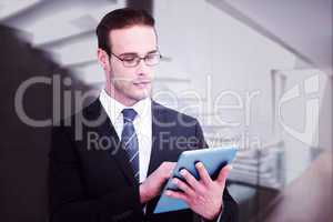 Composite image of unsmiling businessman using tablet pc