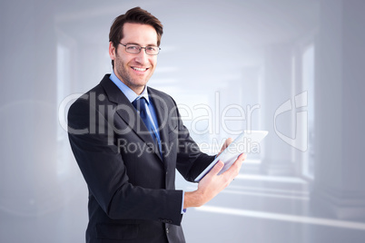 Composite image of businessman looking at the camera while using