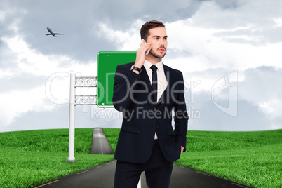 Composite image of serious businessman hand in pocket phoning