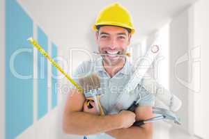Composite image of portrait of smiling handyman holding various
