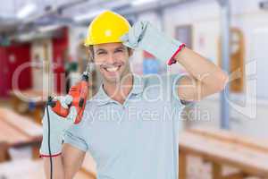 Composite image of handsome architect holding drill machine