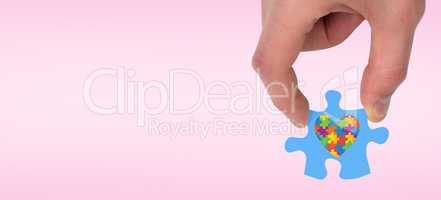 Composite image of hand holding jigsaw piece