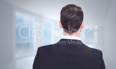 Composite image of rear view of businessman in suit standing