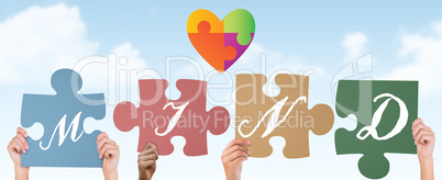 Composite image of hands holding up mind jigsaw pieces