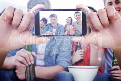 Composite image of hand holding smartphone showing