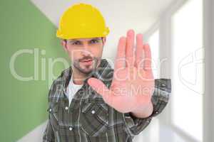 Composite image of confident manual worker gesturing stop sign